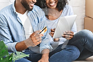 Close up of couple purchasing furniture online, using digital tablet