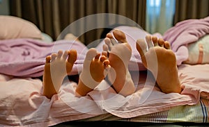 Close Up Of Couple`s Feet While Relaxing In Their Bed