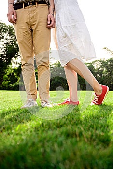 Close up of couple`s legs in keds on grass.