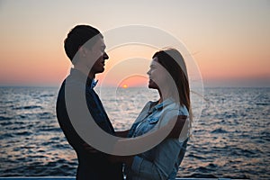 Close up of couple watching the sunrise at the beach summer time, seashore summer beach at yellow blue evening horizon sea, sunset