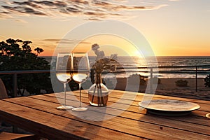 Close up of couple wine champagne glasses and bottle for celebration on wooden table with sea view and sunset sky background,