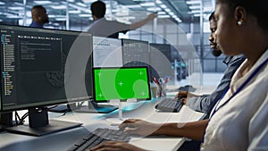 Close up of coworkers coding on chroma key device in data center photo
