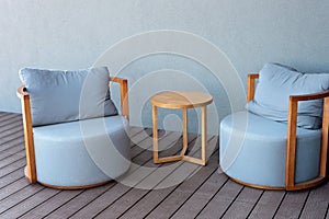 Close-up of cozy light blue upholstered chairs and a wooden table. Modern interior. Furniture for a summer residence. Soft