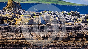 Close up of Crab island with the ruins of a 19th century police post with the cliffs of Moher in the background seen from a boat