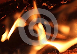 Close up on a crackling warm camp fire burning with red and orange flames