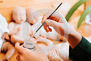 Close-up of craftsman's female hands holding bottle of silicone gel and painting brush in workshop. photo