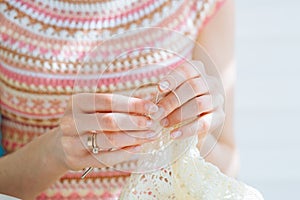 Close up of craftswoman`s hands knitting dress with crochet. Female working with tender lace. Business handmade crochet relaxatio photo