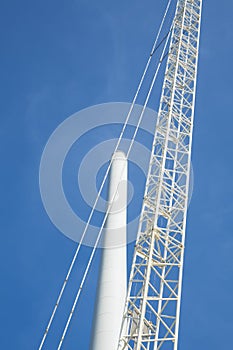 Close up crane and pole of windmill, against blue sky. Space for text.