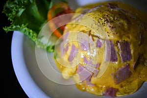Close up Creamy Omelette with ham on steamed rice In a white circular dish