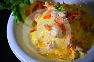 Close up Creamy Omelette with shrimp on steamed rice In a white circular dish