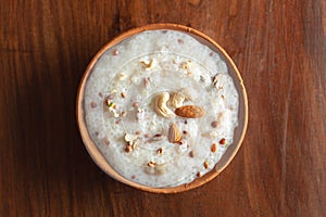 Close-up of Creamy Sabudana Kheer Garnished with dry fruits. Indian delicious dessert. Served in an earthen pot. On Wooden