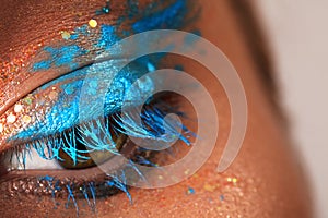 Close-up Creative art make-up. Cream Texture design on female Eye Lid. Makeup with aquamarine paint and bronze pigment