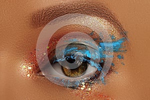 Close-up Creative art make-up. Cream Texture design on female Eye Lid. Makeup with aquamarine paint and bronze pigment