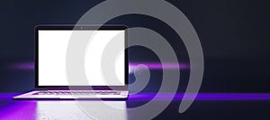 Close up of creative neon purple light gaming laptop computer with empty white mock up screen.