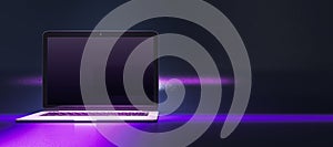 Close up of creative neon purple light gaming laptop on dark wide background with mock up place.