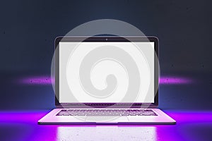 Close up of creative neon purple light gaming laptop with empty white mock up screen.