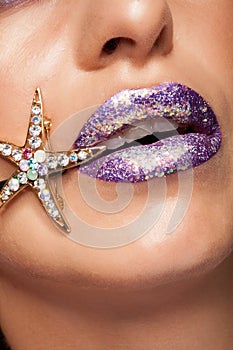 Close up of creative purple lipstick with glitter and diamond star