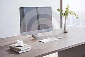 Close up of creative wooden designer desktop with blank mock up computer monitor, coffee cup, other items, window with city view