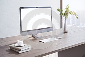 Close up of creative wooden designer desktop with blank white mock up computer monitor, coffee cup, other items, window with city