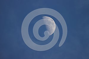 Close up of the crescent moon in the daytime with blue sky