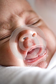 Close-up cropped face of newborn baby boy crying