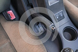 a close up cropped hand using the handbrake, driver sitting inside the car