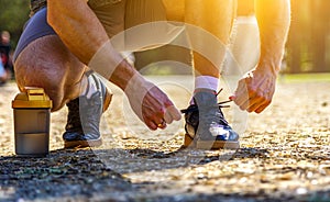 Close up cropped image of caucasian sportsman tying shoelaces