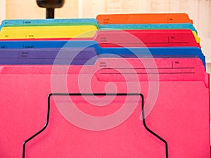 Close-up cropped image of pen and files with keyboard and spectacles on wooden office desk.