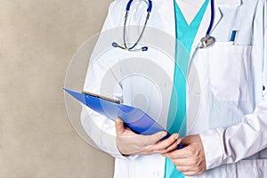 Close-up, cropped man in a white medical coat. The doctor holds the patient`s card.