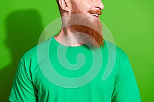 Close up cropped photo of virile man with ginger beard dressed green t-shirt look at promo empty space isolated on green