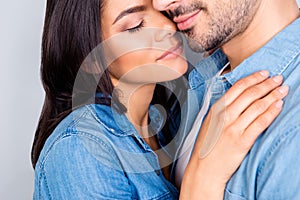 Close up cropped portrait of beautiful cute lovely couple enjoying each other with closed eyes over grey background, she likes sm