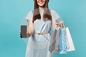 Close up cropped portrait of woman in summer dress hold packages bags with purchases after shopping, mobile cellphone