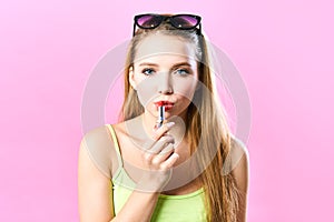 Close up cropped shot of femenine gorgeous charming adorable lady, with beautiful sexy lips, tube of hard pink pomade in