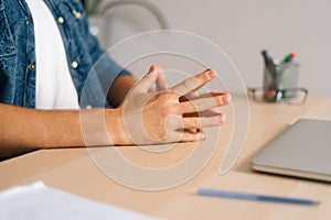 Close-up cropped shot hands of unrecognizable nervous business man sitting in closed posture, tension or nervous