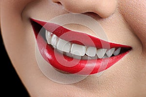 Close up cropped shot of a perfect smile of a red lipped woman