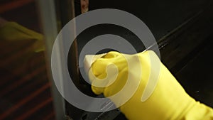 Close-up cropped shot of unrecognizable male housewife in rubber gloves cleaning dirty oven of grease with steam cleaner