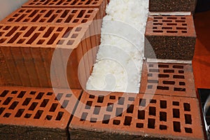 A close-up of cross-section of an unfinished energy efficient, thermal insulated house wall built from porous ceramic blocks,