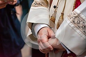 Close Up Of Crossed Chubby Hands Of A Priest