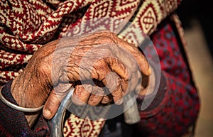 Close up of the crossed wrinkle hands of an elder grandmother nepalese woman.
