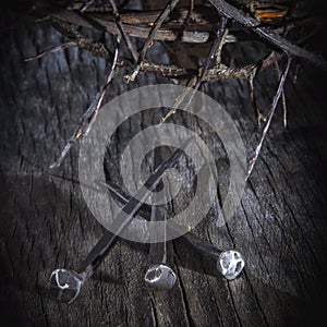 Close up crown of thorns and nails again vintage wooden background as symbol of crucifixion of Jesus Christ