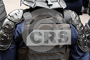 Close-up 'CRS' (riot police) marking written on the back of a tactical vest, Paris, France