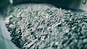 Close up of crumbled ore on the transporting machine. Mining industry, fossil, minerals processing.