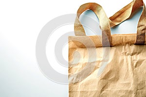 Close-up of crumpled brown paper shopping bag with fabric handles photo