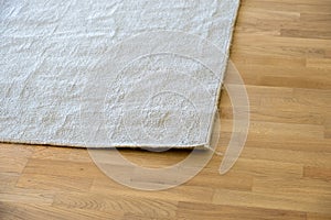 Close up of crumpled carpet laying on parquet wooden floor