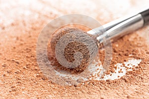 Close-up of crushed mineral shimmer powder golden color with makeup brush