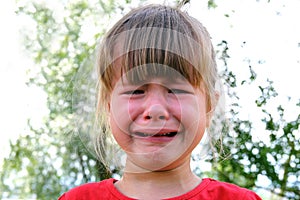 Close-up of crying little girl outdoors