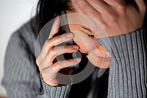 Close up of crying woman calling on smartphone photo