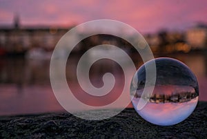 close-up of crystal ball on rock at beach against sky during sunset