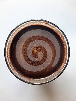 A close up of a cup of black coffee on a white surface. photo