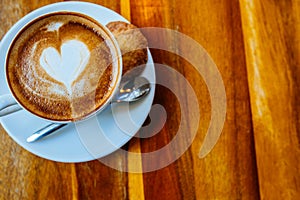 Close up cup of cappuccino in a white cup on a saucer with cookies. Top view copy place